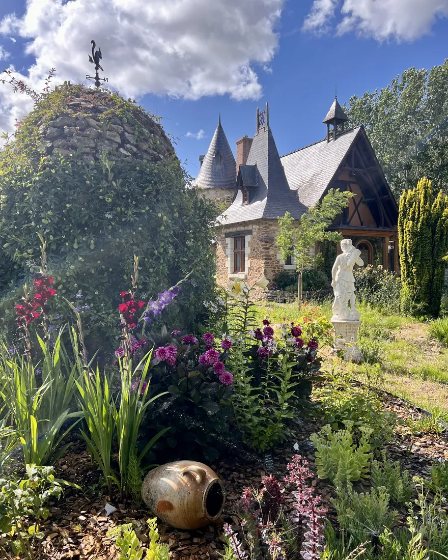 Massifs de fleurs du jardin devant la maison, à Corné